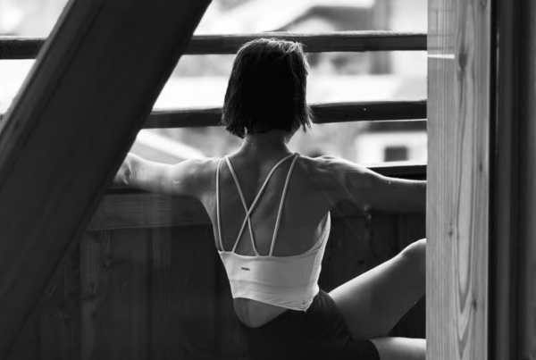 Frau mit Rücken zugewandt sitzend in Yoga-Pose
